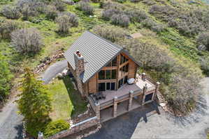 Rustic wood-sided home featuring a stone chimney and a metal roof