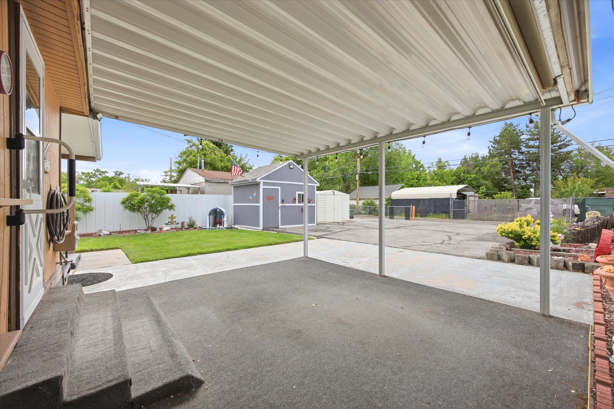 Covered patio space featuring a concrete slab and string lighting
