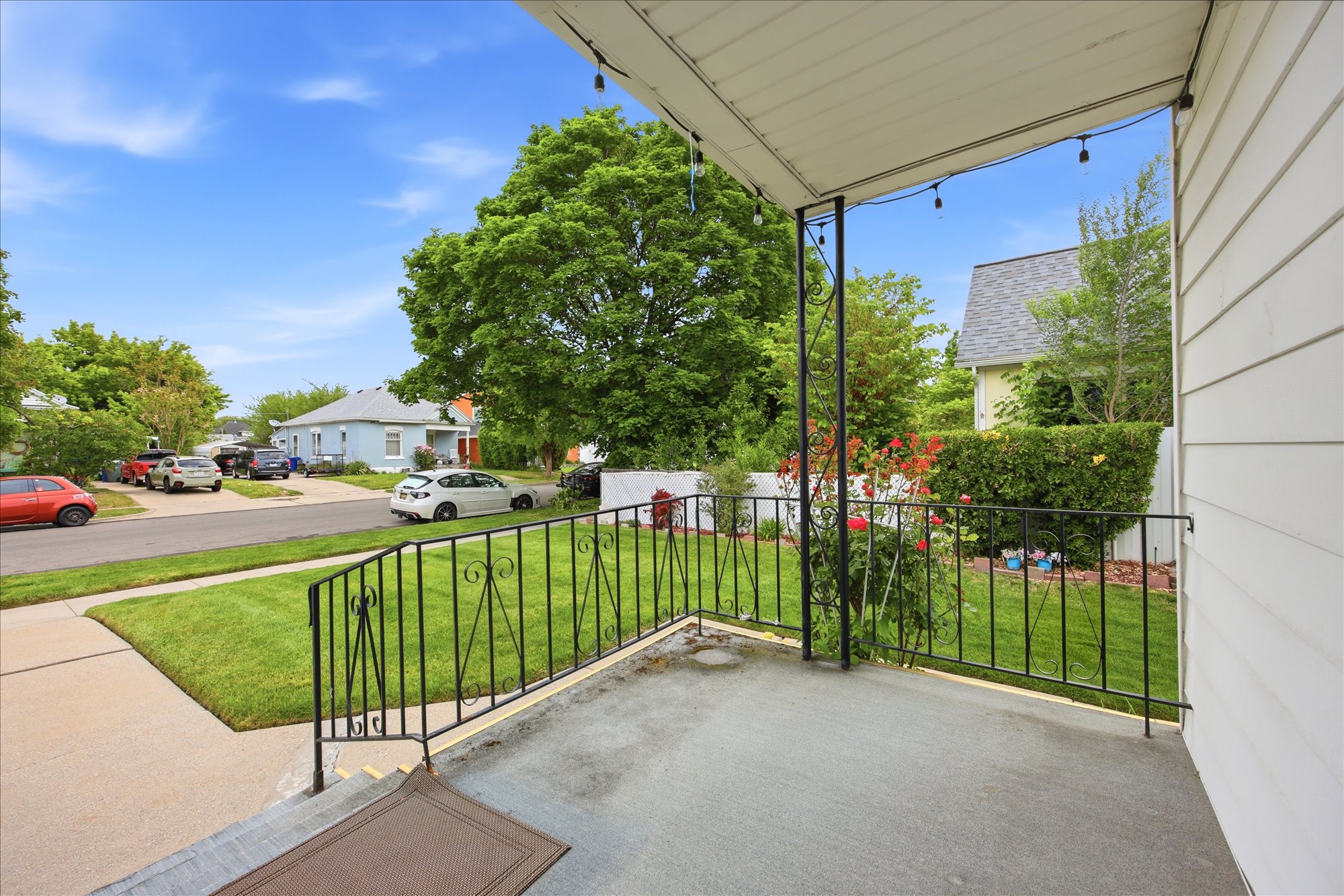 Covered porch with concrete flooring and wrought iron railing