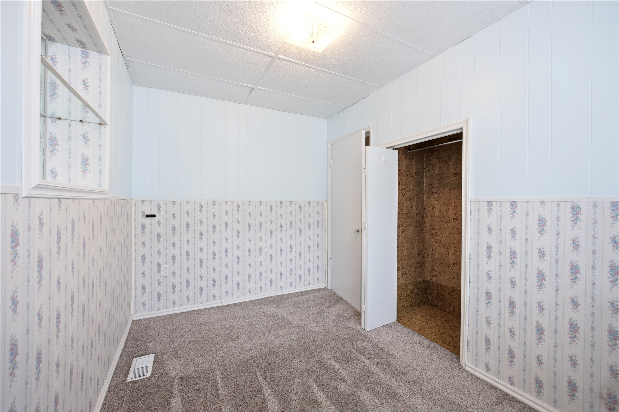 Carpeted room with patterned wainscoting and light blue paneling