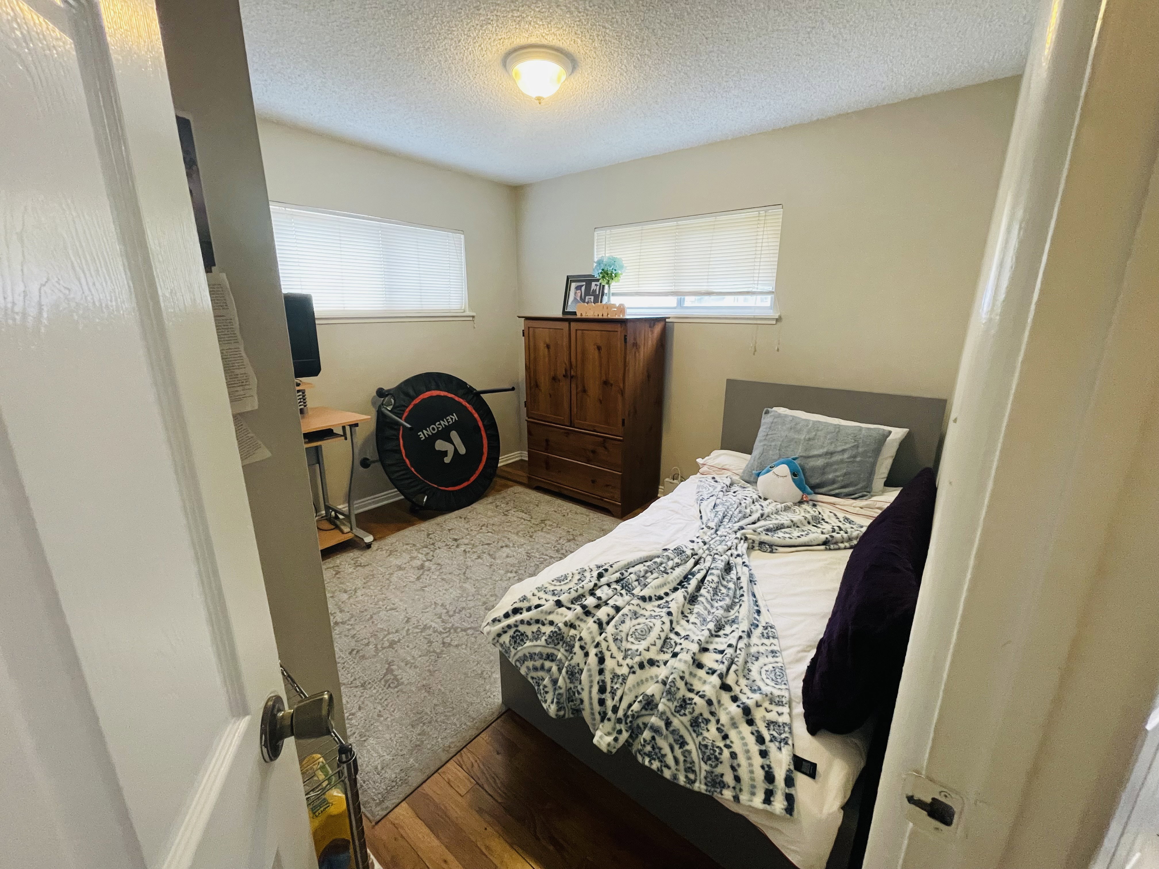 Bedroom featuring wood-finish flooring, light-toned wall paint, and a textured ceiling