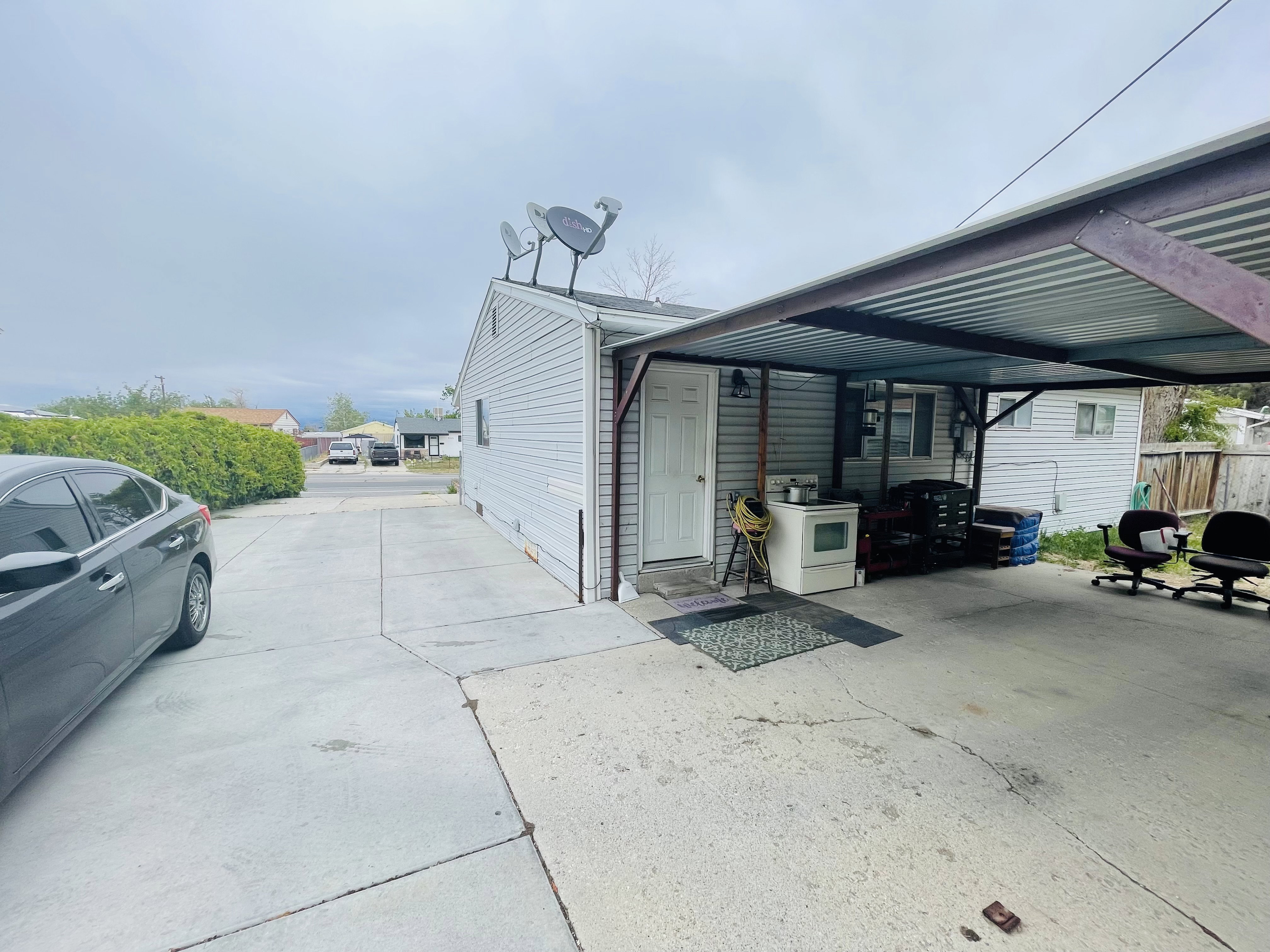 Concrete driveway extending to a covered carport