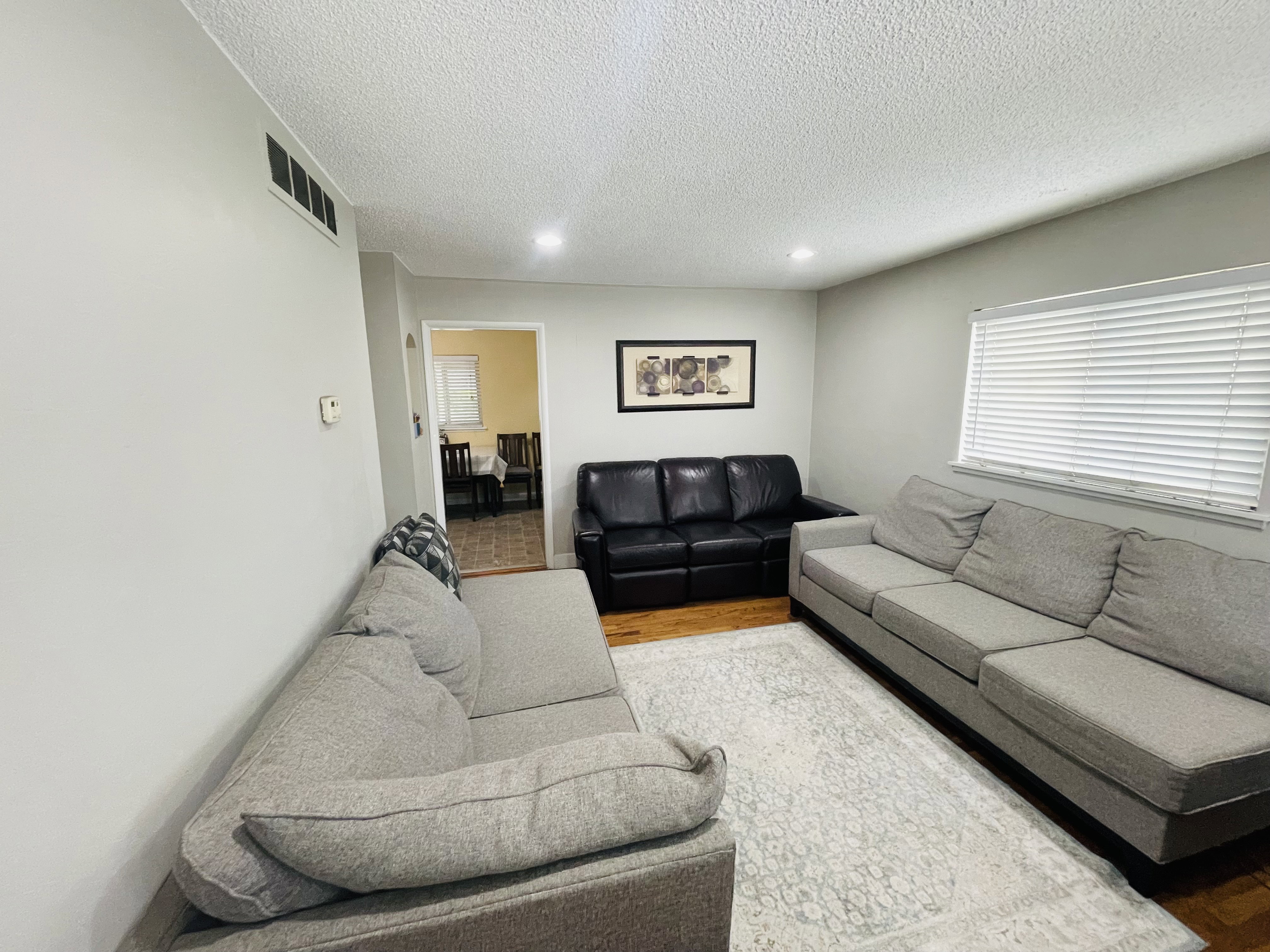 Living area featuring light gray wall paint and recessed ceiling lighting