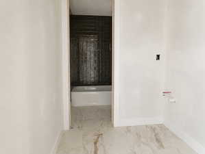 Bathroom featuring marble-look flooring and white baseboards
