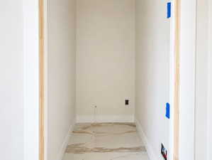 Alcove featuring large format stone-look tile flooring, light-toned walls, and white trim