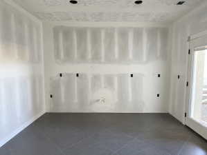 Interior space featuring unfinished drywall, recessed lighting, and large format tile flooring