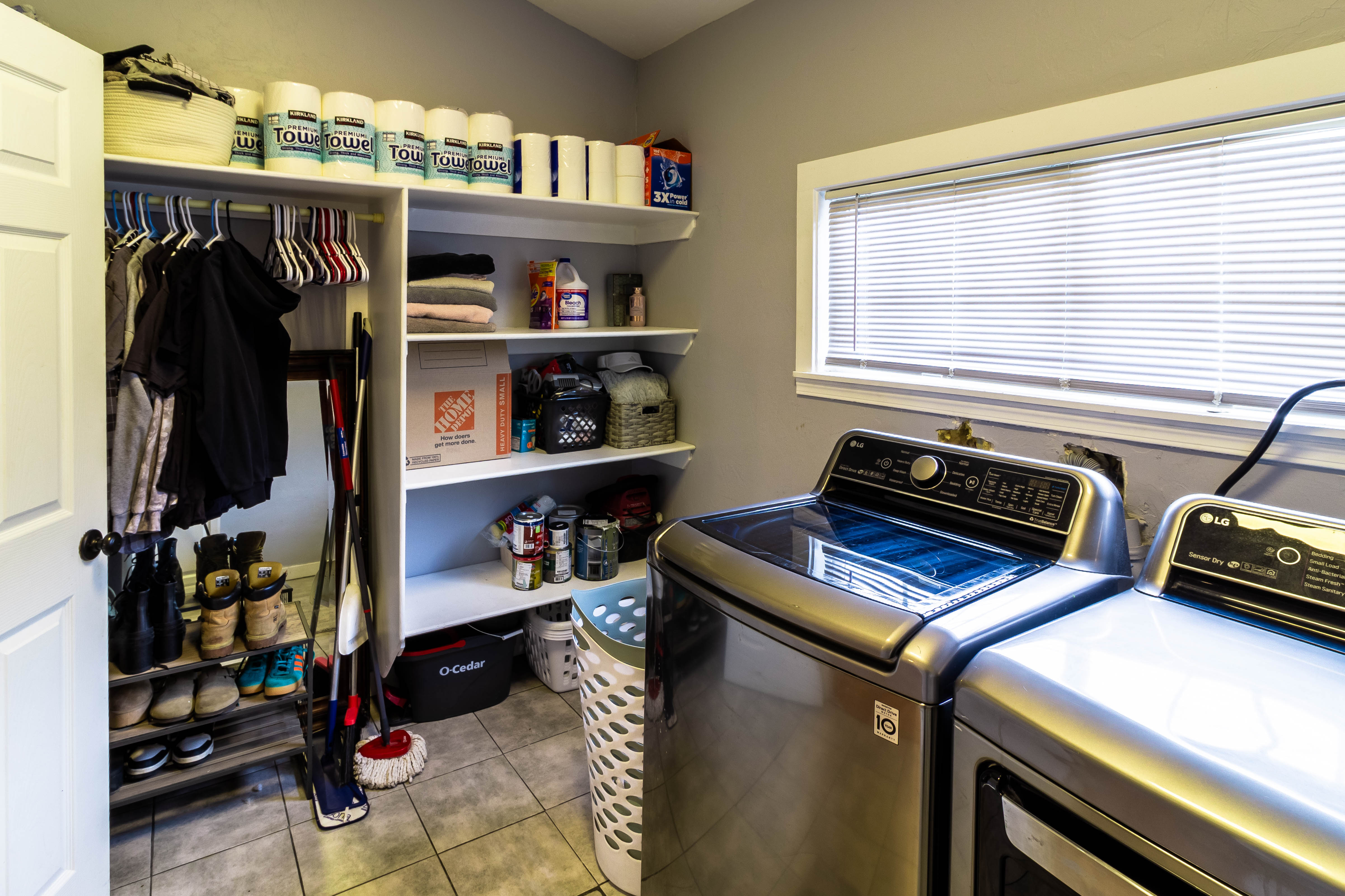 Laundry area featuring tile flooring, a window with blinds, and built-in shelving