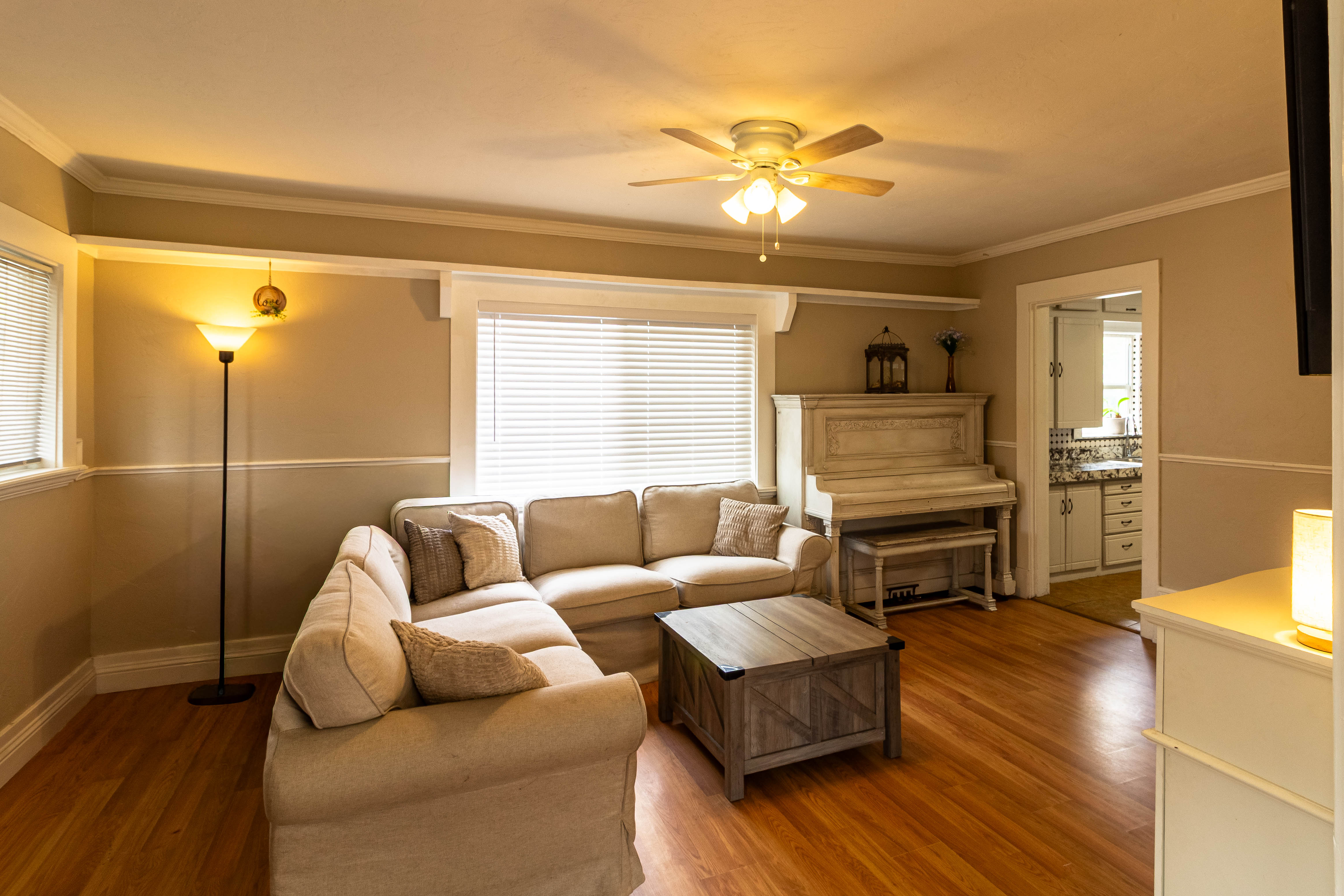 Hardwood flooring throughout, crown molding, and a ceiling fan with integrated lighting