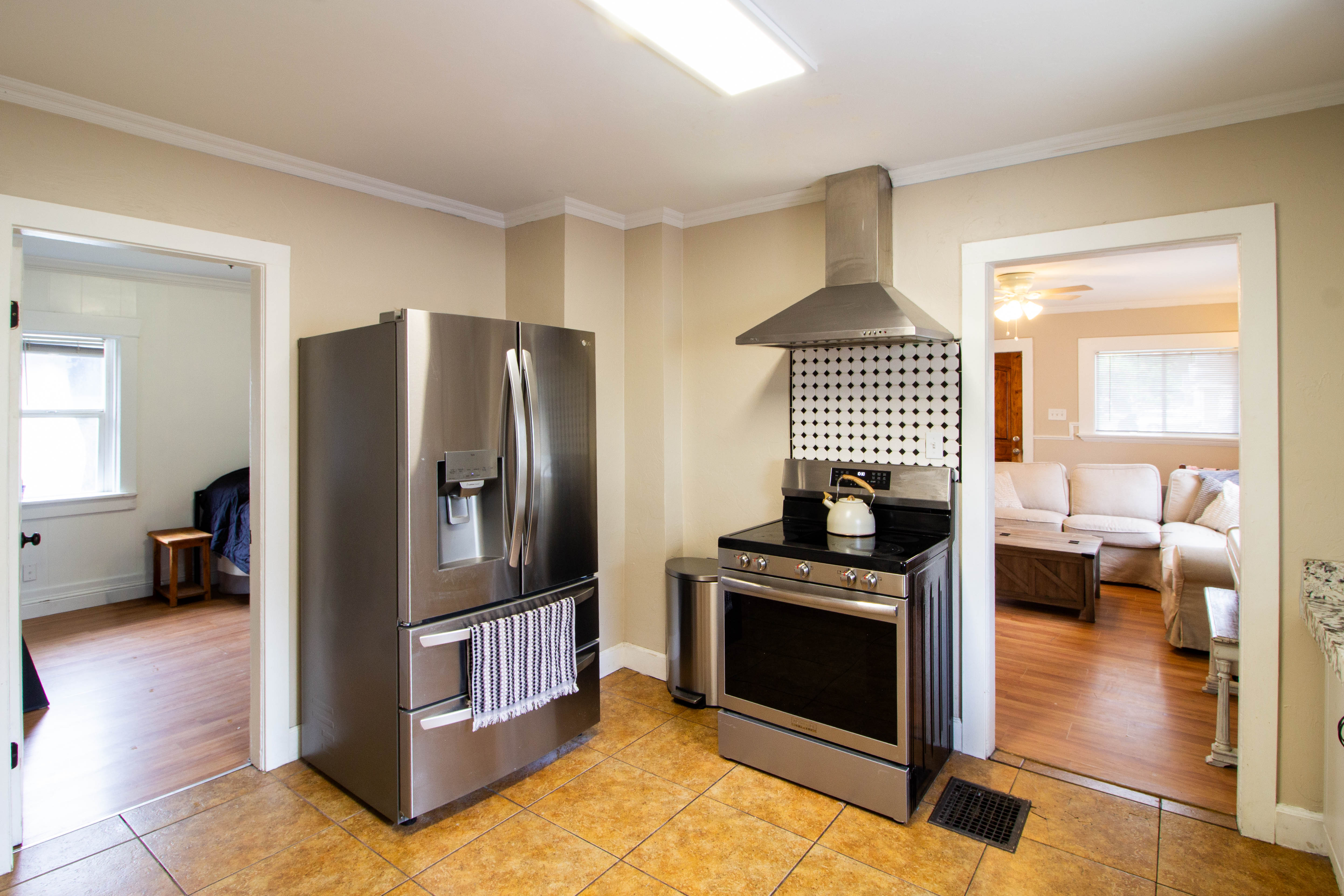 Kitchen featuring stainless steel appliances, tile flooring, and crown molding