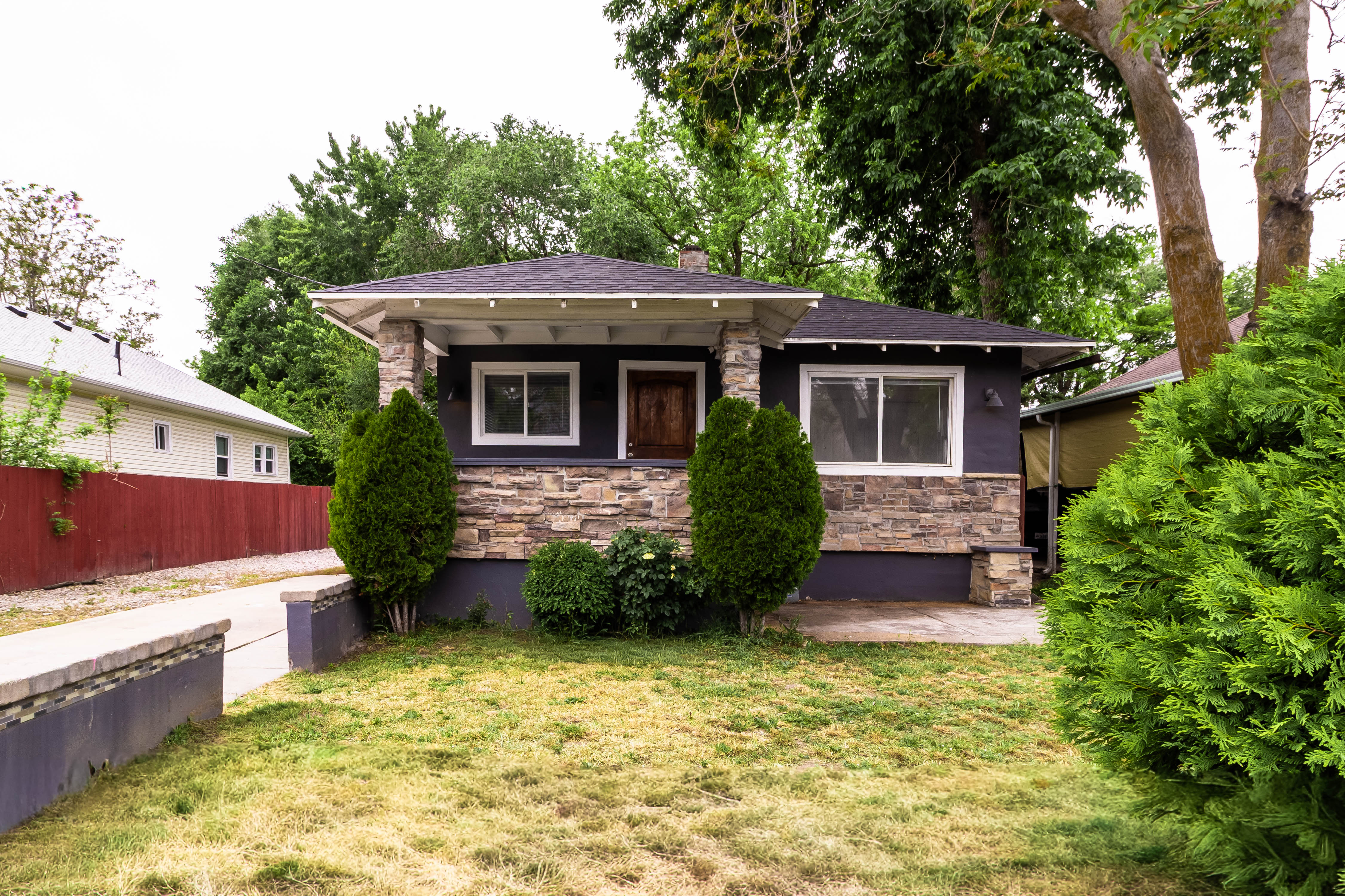 Craftsman-style exterior with stone veneer accents and dark siding