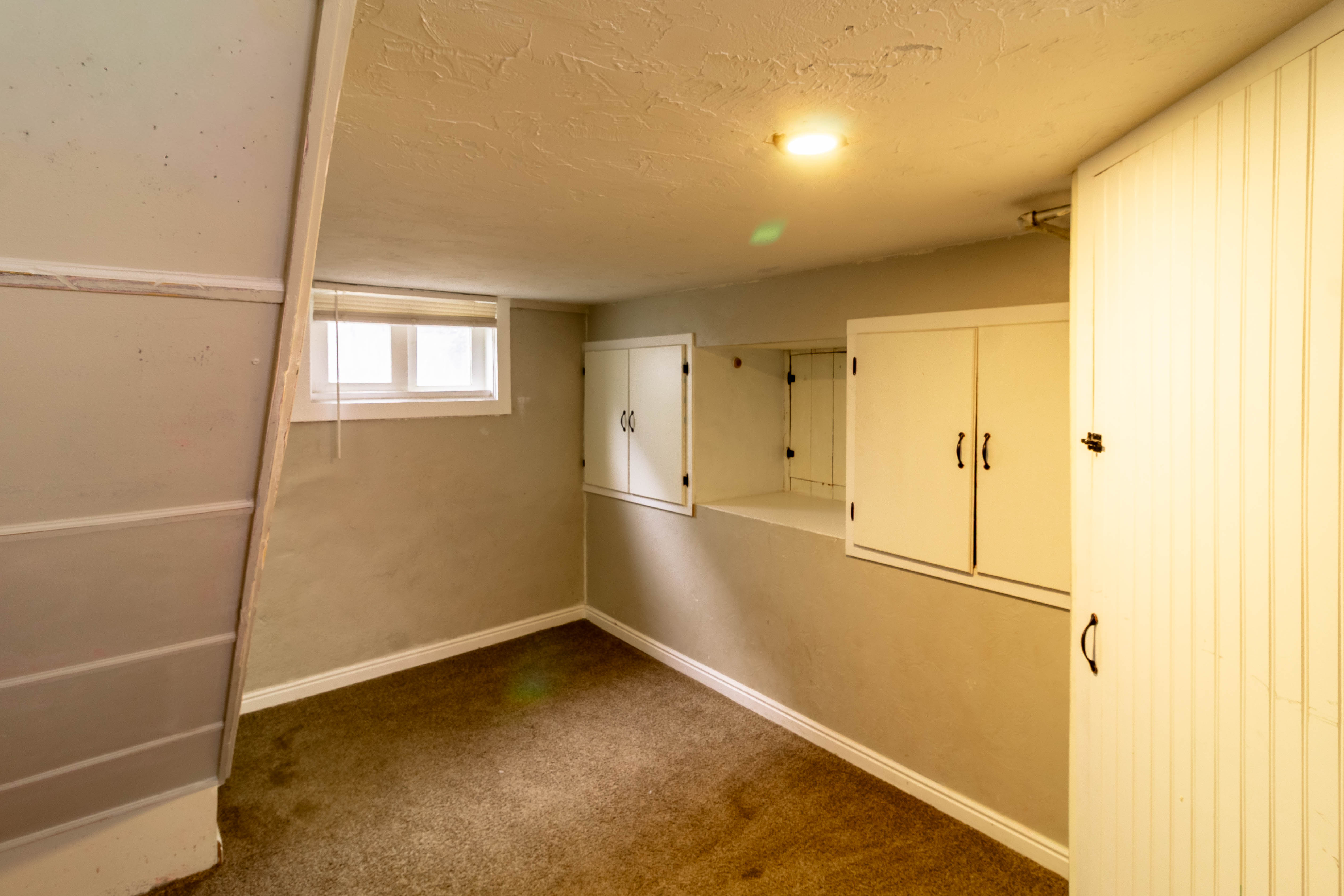 Sub-grade room featuring a window, built-in cabinetry, and neutral wall tones
