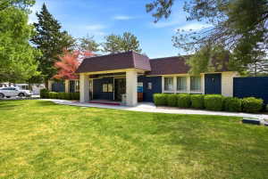 Exterior building featuring blue siding, white brick, and a brown shingle roof