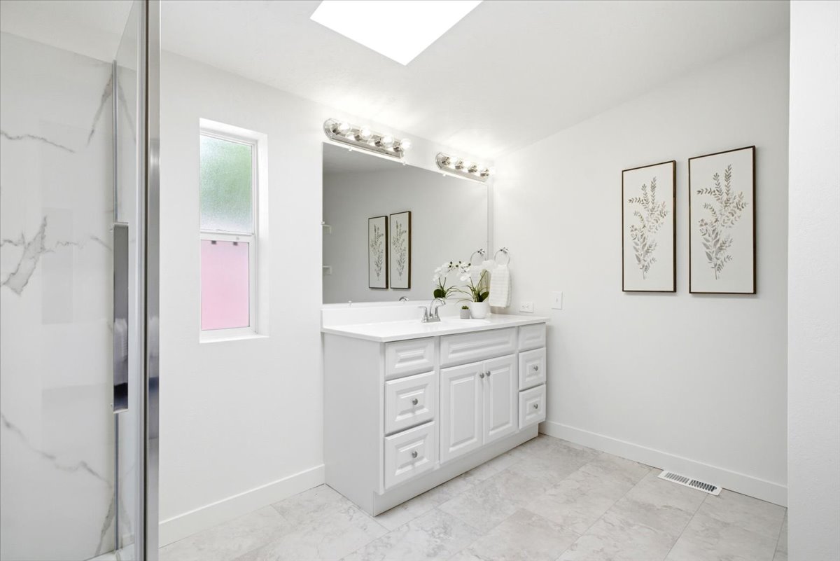 Bathroom featuring a white shaker-style vanity with a white countertop and rectangular undermount sink