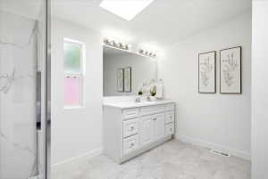 Bathroom featuring a white shaker-style vanity with a white countertop and rectangular undermount sink
