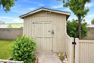 Vertical plank storage shed with an asphalt shingle roof