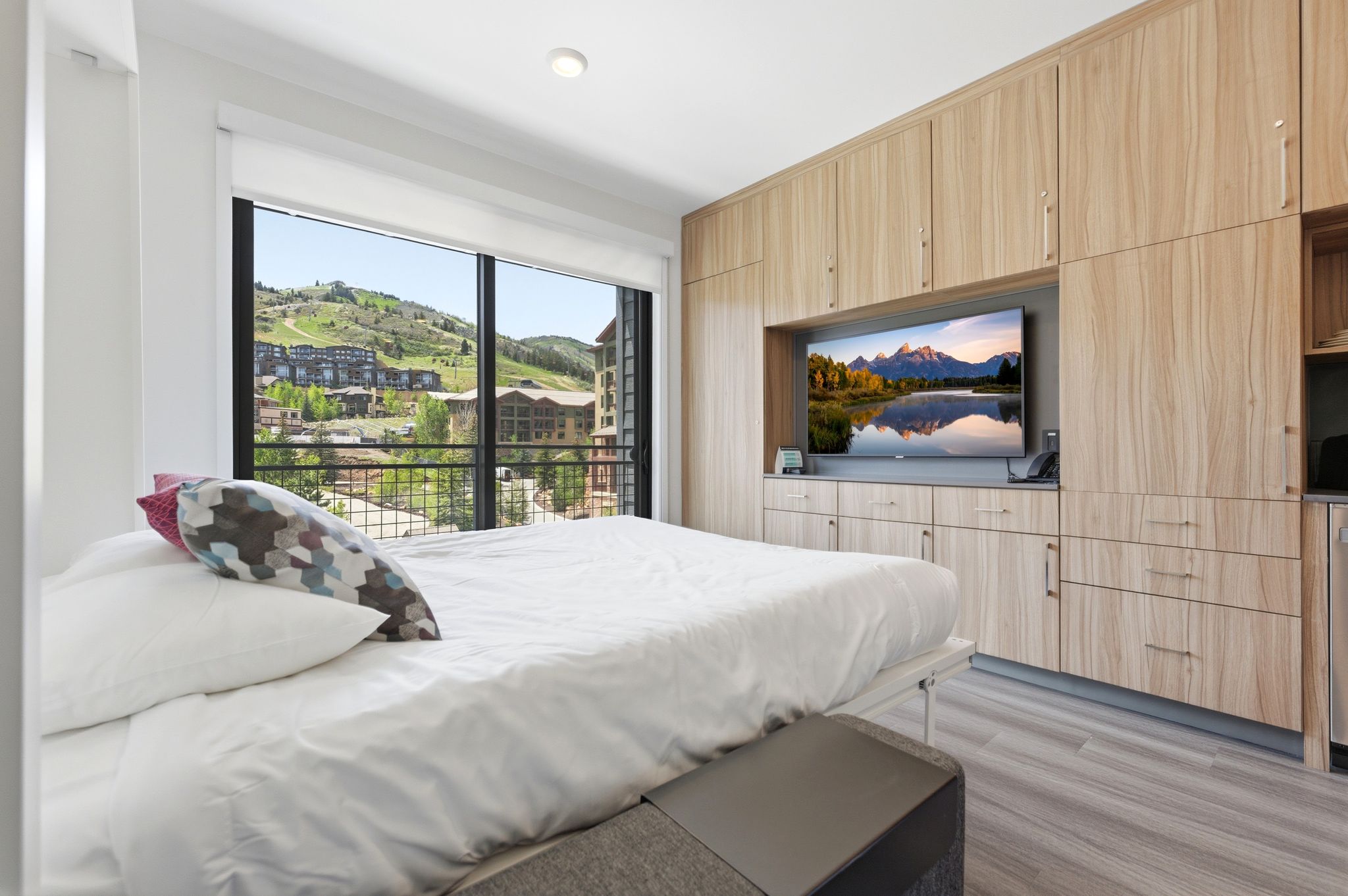 Floor-to-ceiling windows with mountain and community scenery