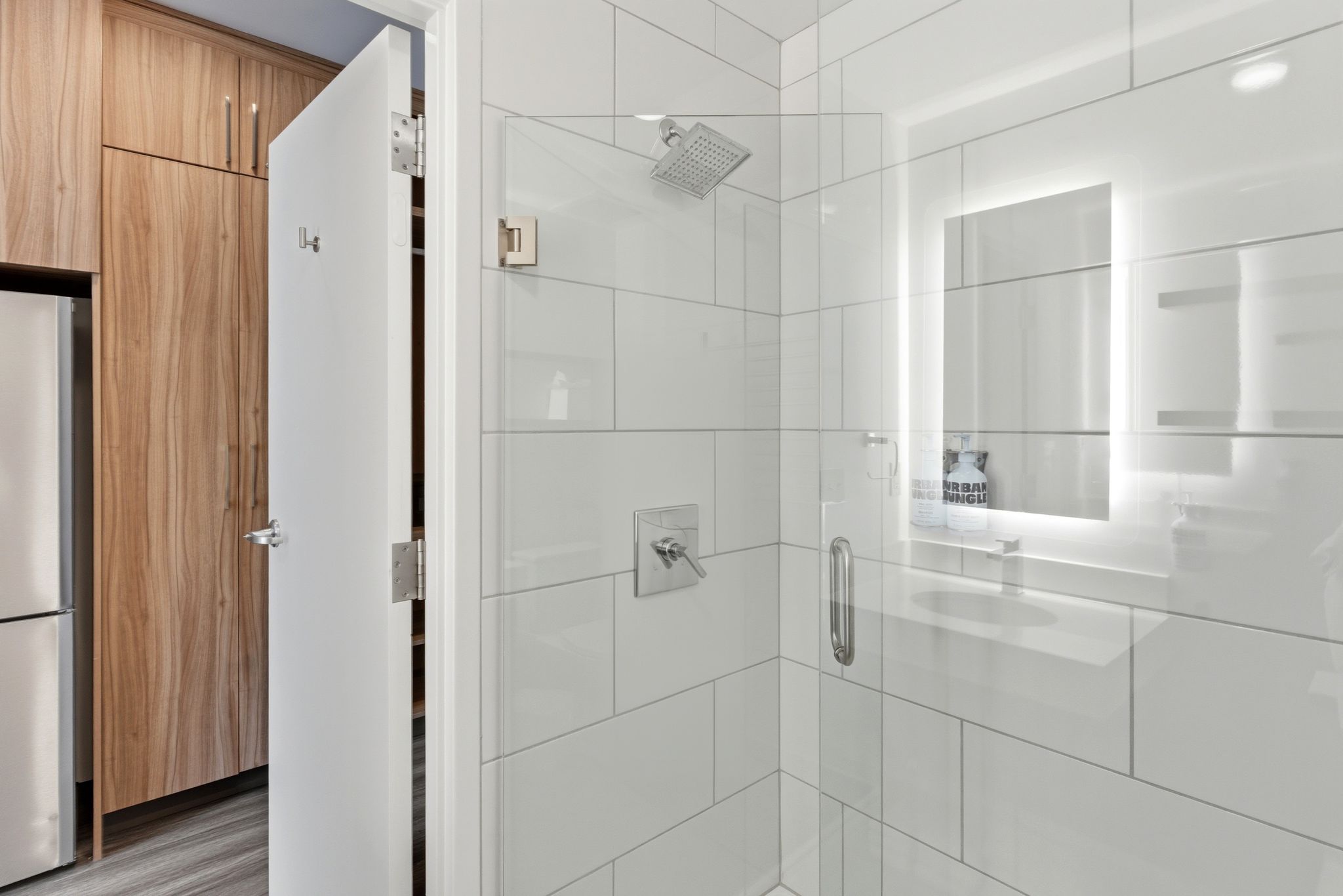 Contemporary bathroom featuring a spacious glass-enclosed shower with a rainfall showerhead and wall-mounted controls