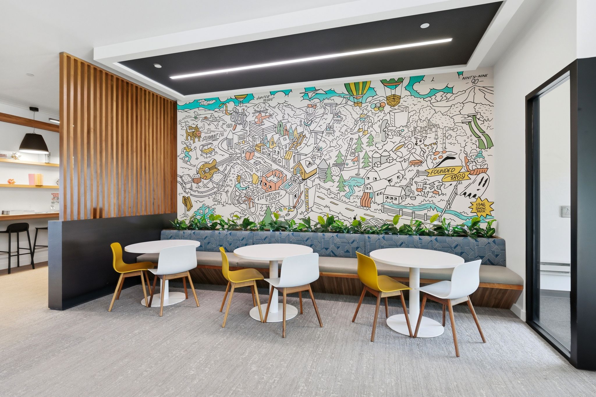 Contemporary common area featuring a built-in banquette with planters, a custom wall mural, and light-toned flooring