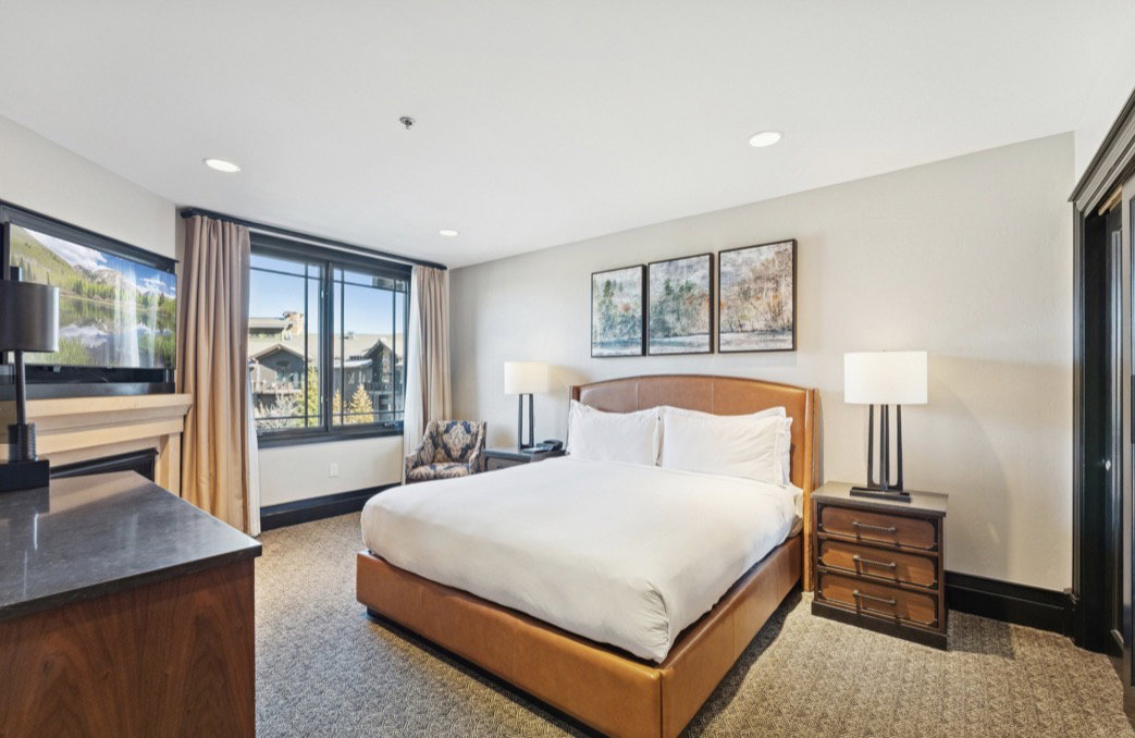 Carpeted room featuring a built-in fireplace with a stone mantel, a large window with exterior views, and recessed lighting