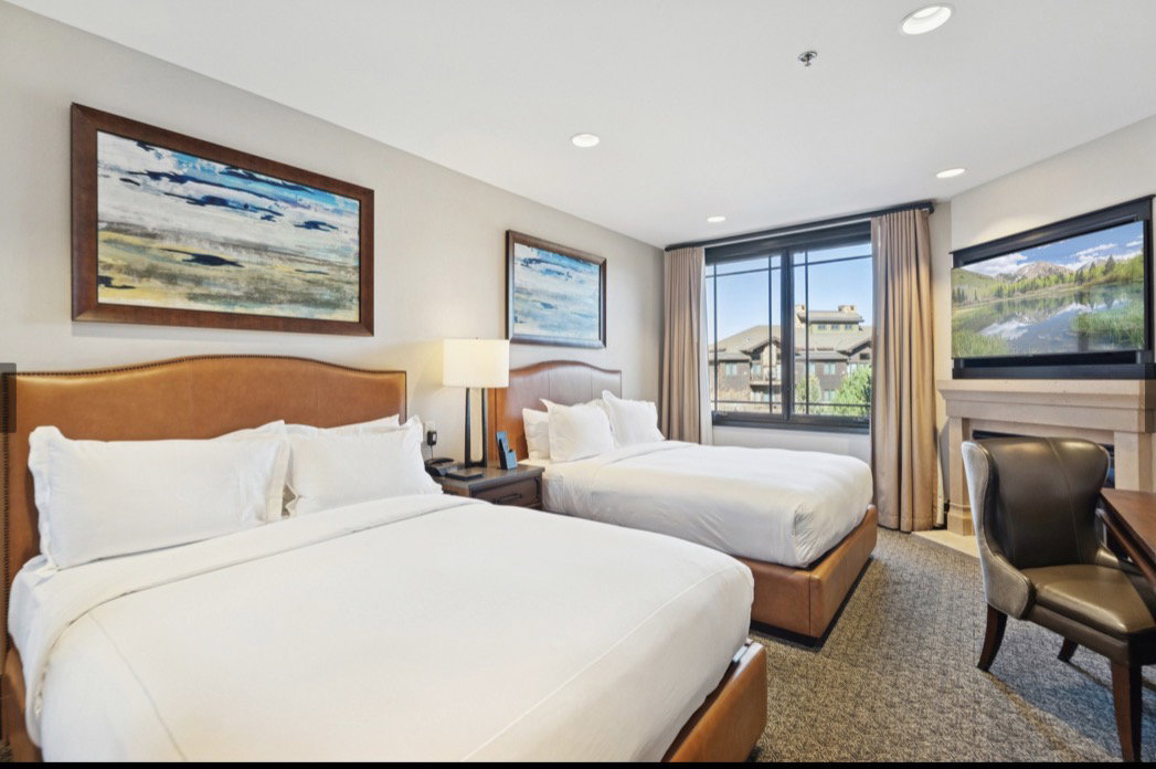 Two beds with leather-finish headboards and bases