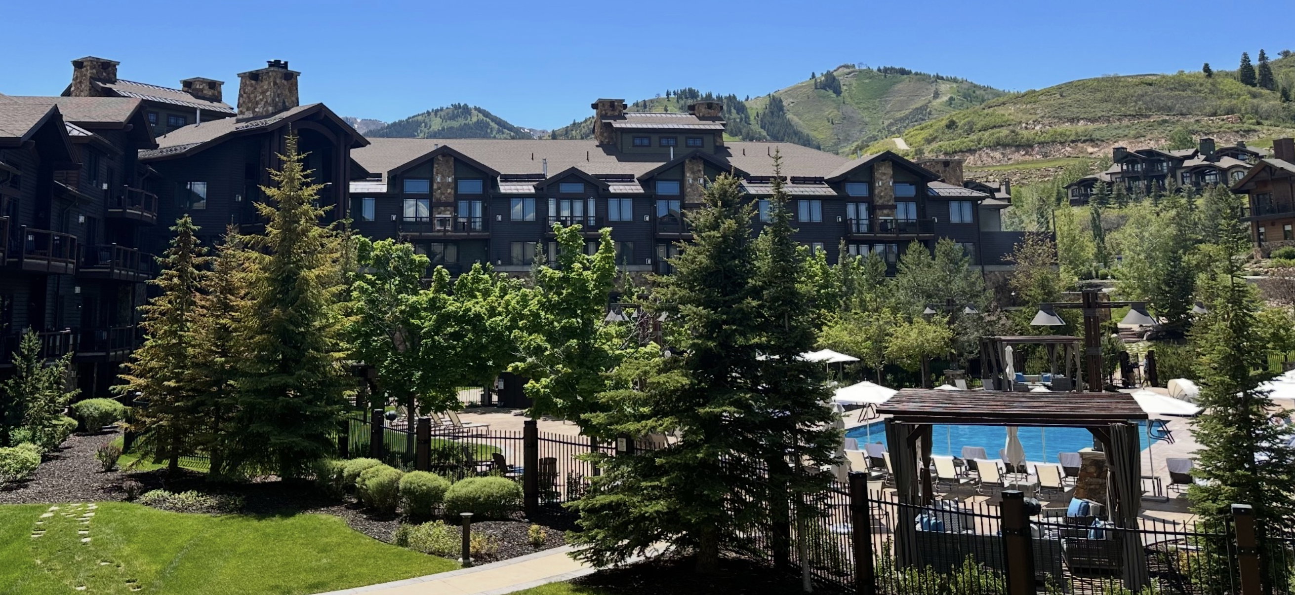 Mountain lodge-style building featuring multiple balconies, stone accents, and a dark facade