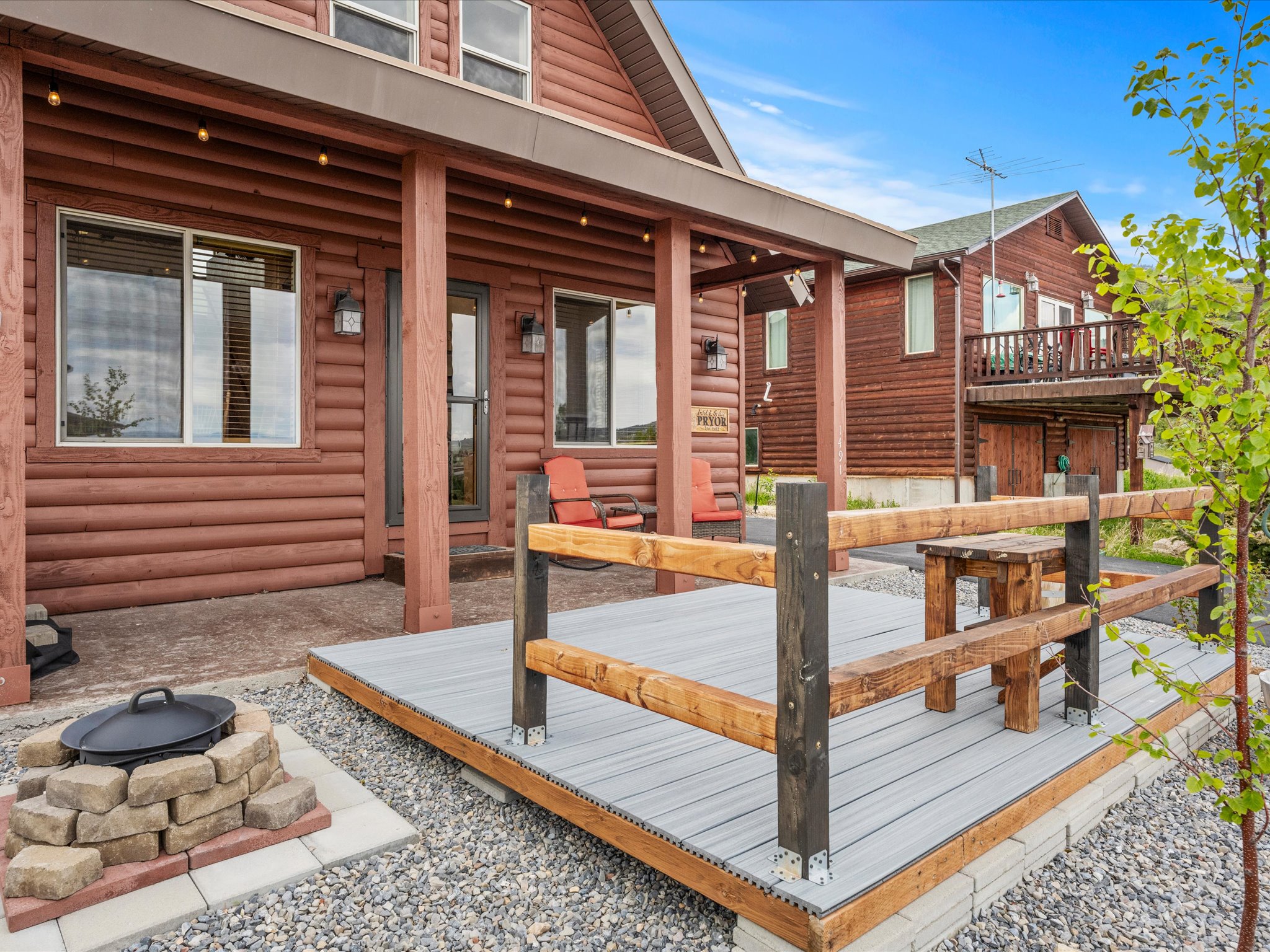 Exterior featuring log-style siding and a covered porch with string lights