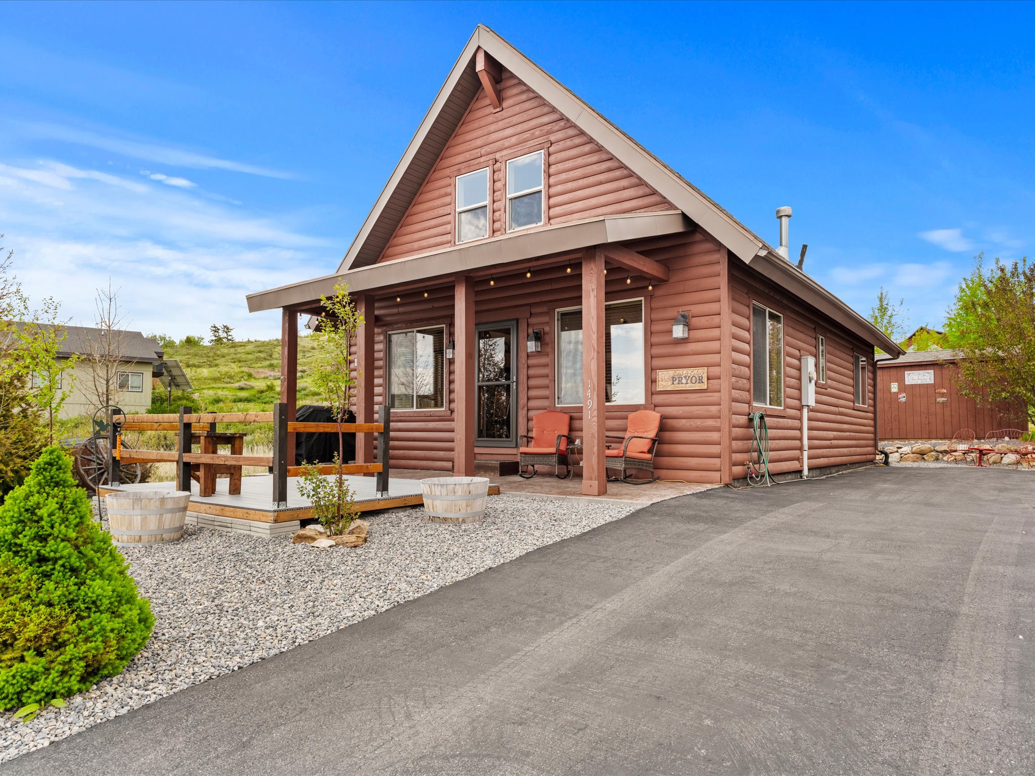Log-style exterior with a covered front porch featuring string lighting