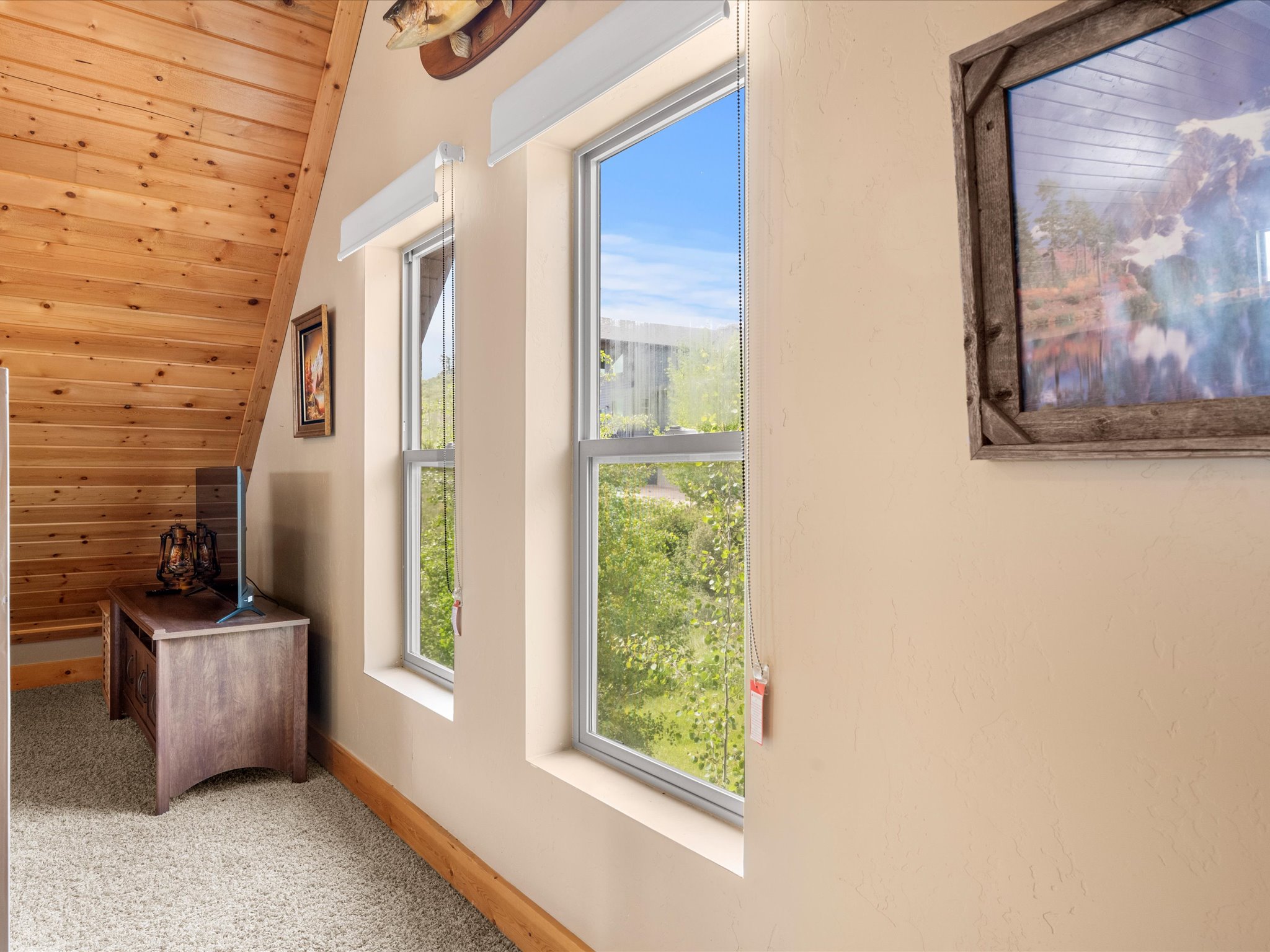 Sloped wood-paneled ceiling with natural wood finish flooring