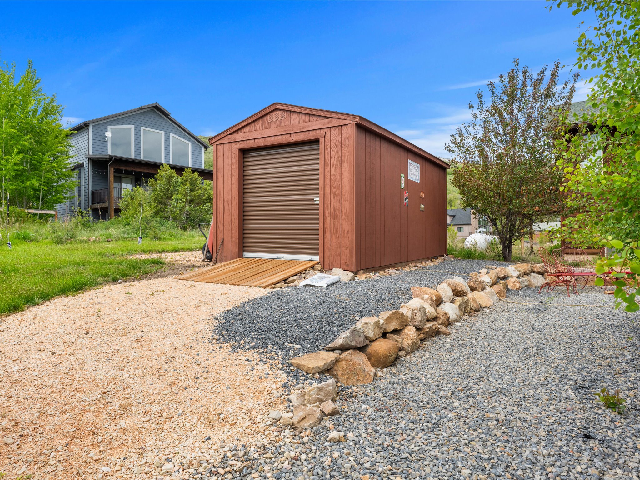 Freestanding storage shed with a roll-up door and wood ramp access