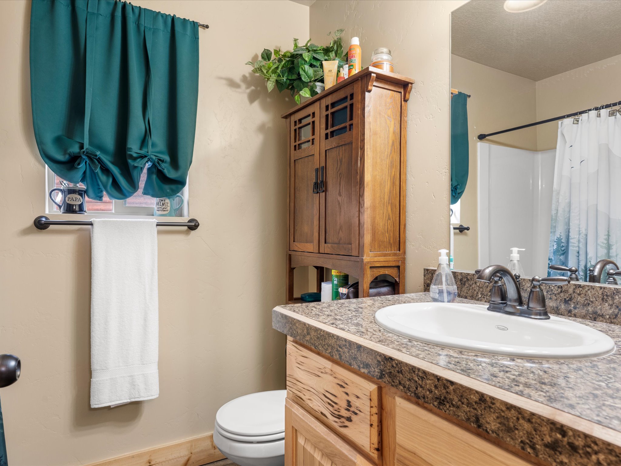 Bathroom featuring a vanity with an integrated sink, a speckled countertop, and wood-finish cabinetry