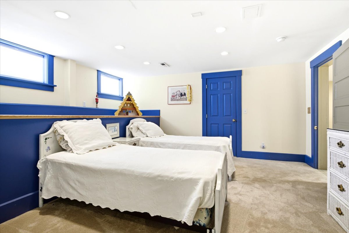 Recessed lighting illuminates this room featuring vibrant blue trim and wainscoting