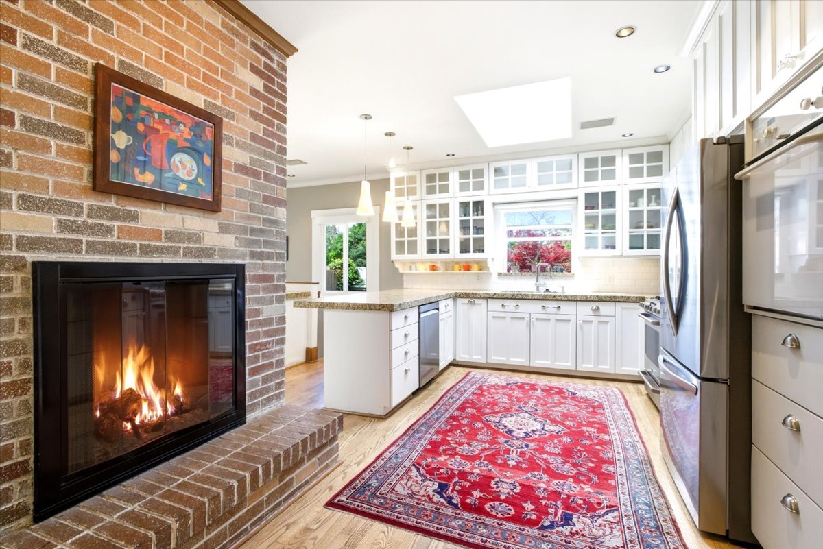 Open-concept kitchen featuring white cabinetry, light-toned countertops, and stainless steel appliances