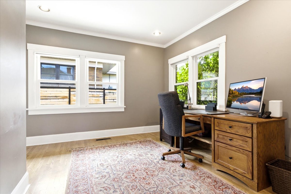 Room featuring wood-finish flooring, recessed ceiling lighting, and multiple windows with white trim