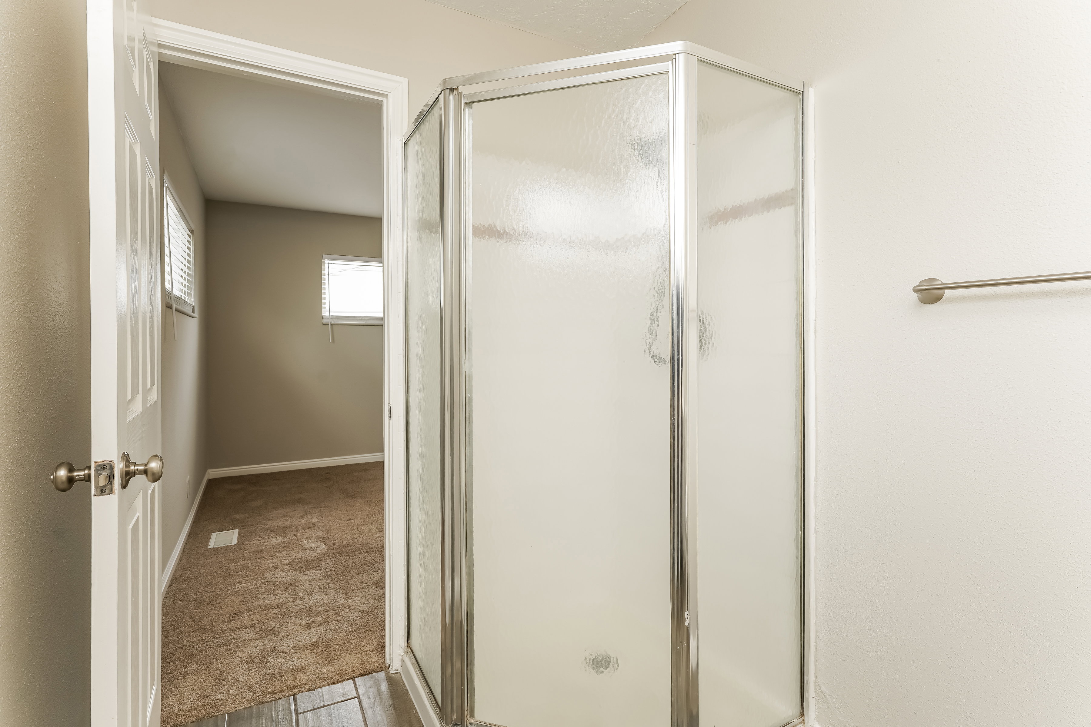 Corner shower stall with frosted glass panels and chrome framing