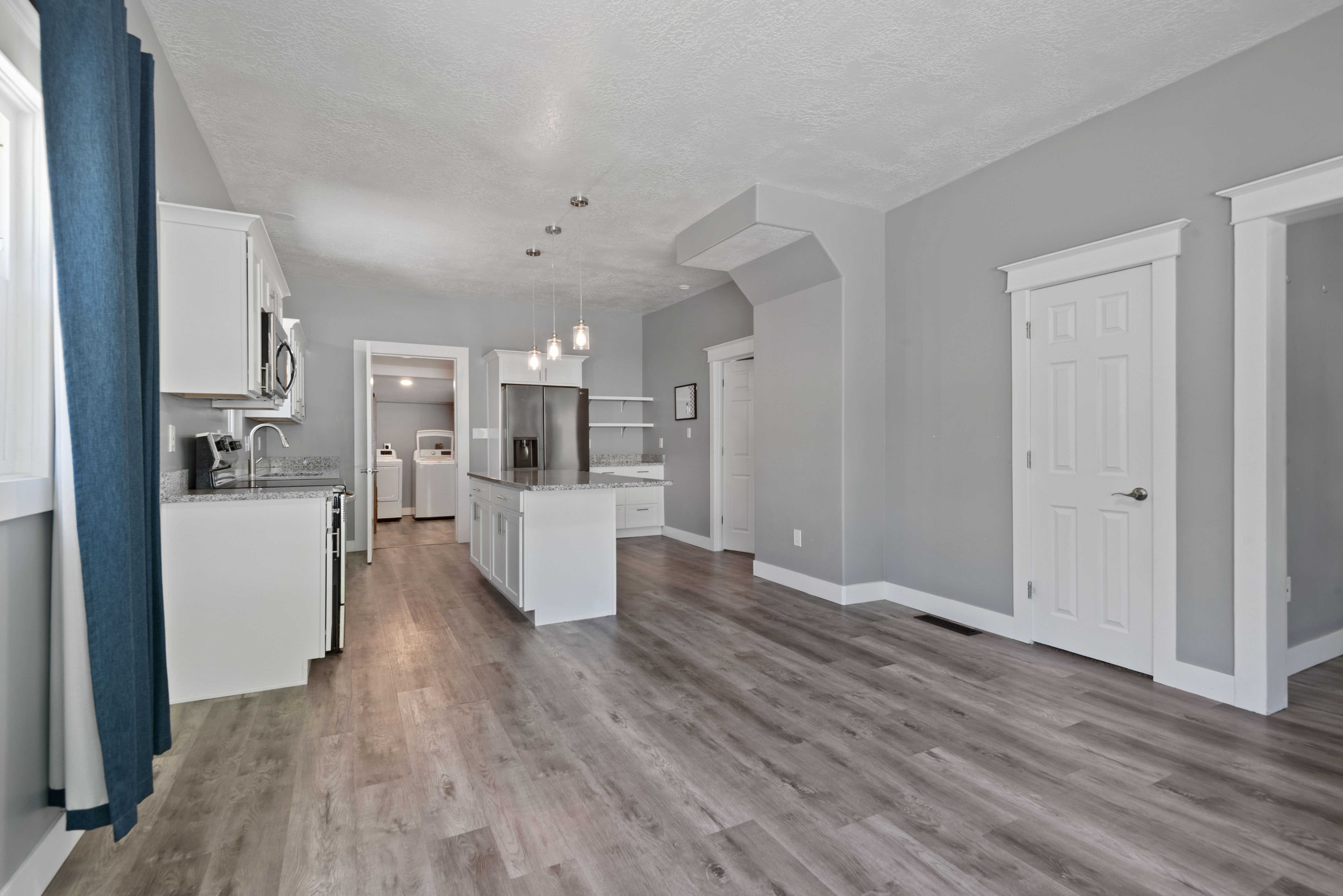 Spacious room featuring wood-finish flooring and light gray walls
