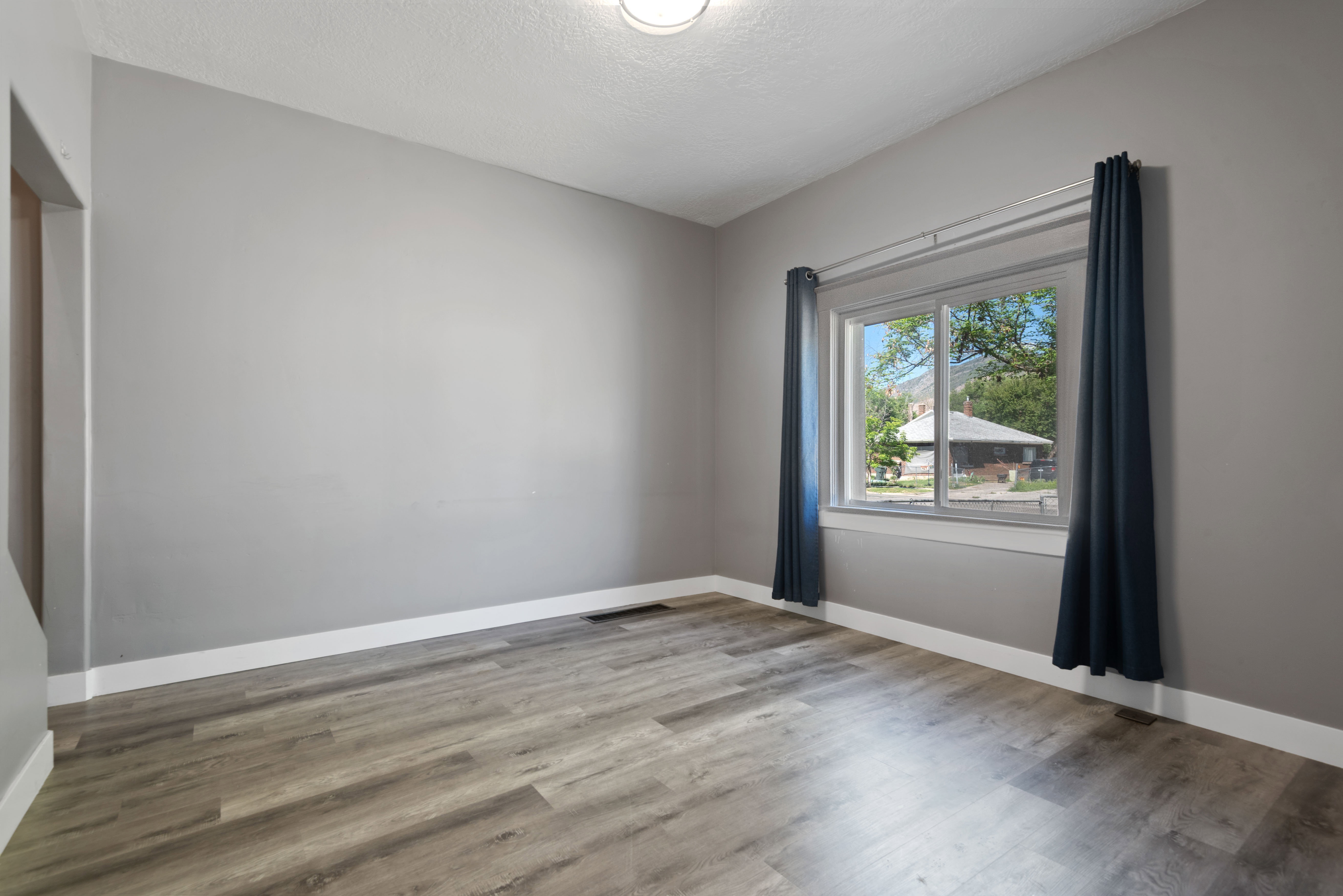 Interior room with wood-finish flooring, light gray wall color, and white baseboards