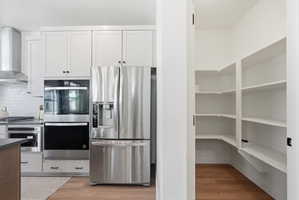 Modern kitchen design featuring white shaker cabinetry, stainless steel appliances, and a built-in wall oven with microwave