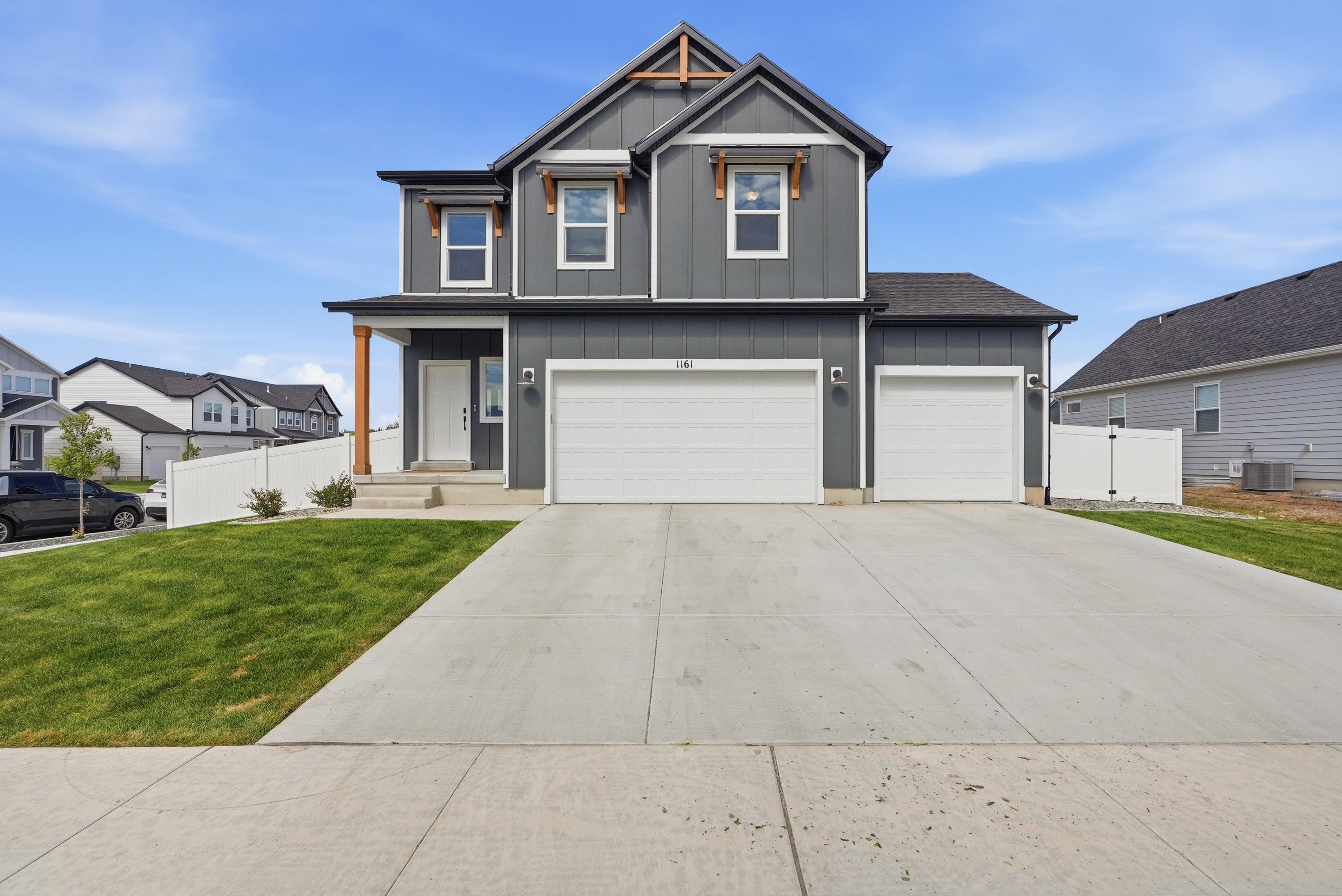 Two-story residence featuring dark gray siding, white trim, and a prominent front gable