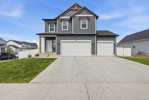 Two-story residence featuring dark gray siding, white trim, and a prominent front gable