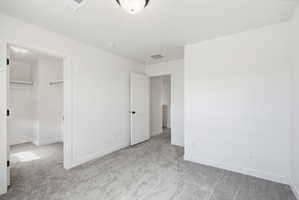Carpeted room with white walls, two interior doors, and overhead lighting