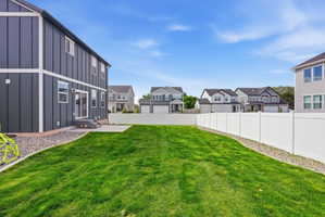 Spacious backyard featuring a manicured lawn, a concrete patio, and a privacy fence