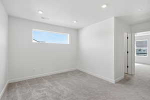 Carpeted room with a horizontal window and recessed lighting