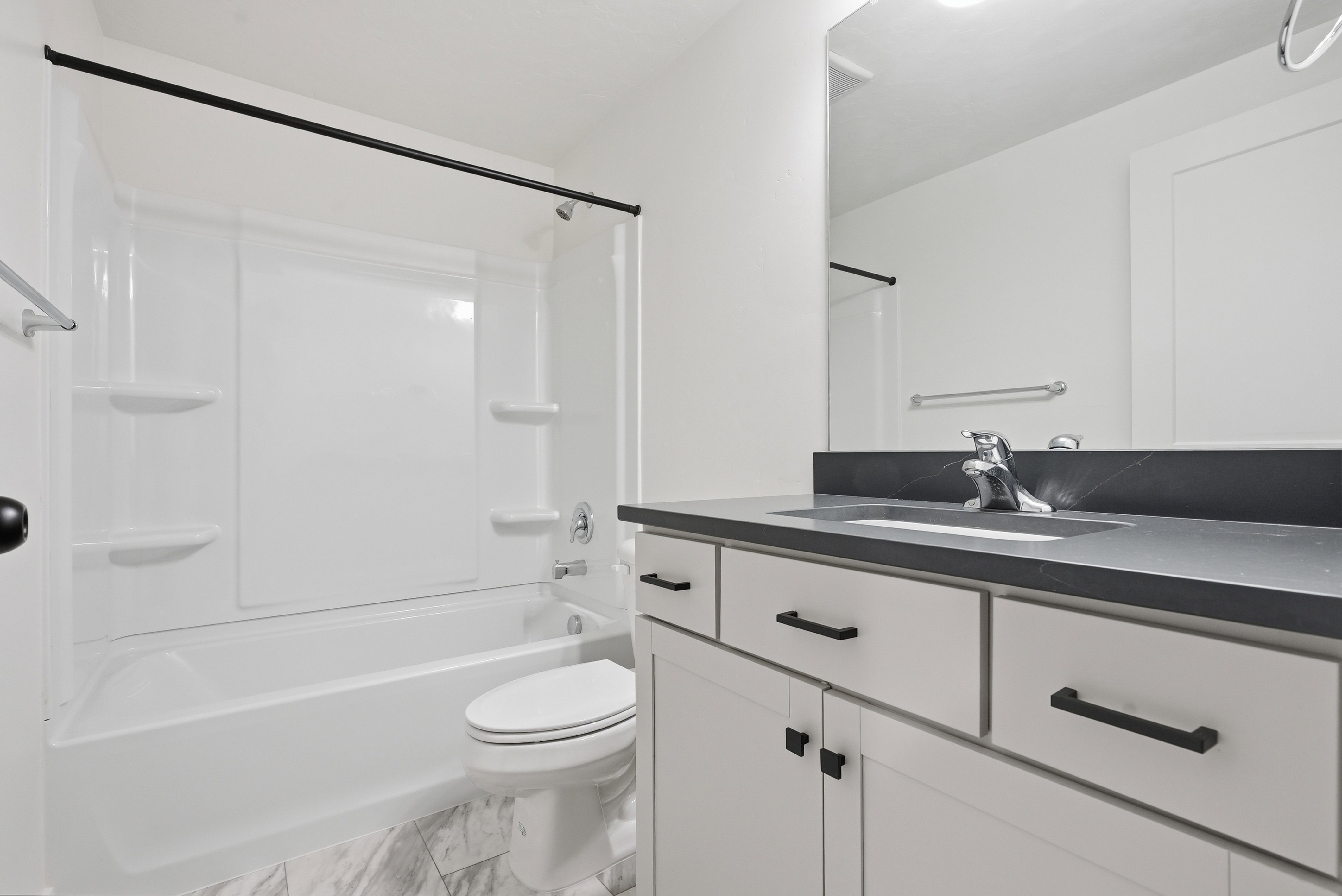 Bathroom featuring a white tub/shower combination with integrated shelving