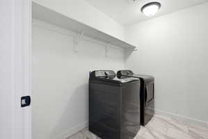 Laundry area featuring a ceiling-mounted light fixture, white walls, built-in shelving, and light-toned tile flooring