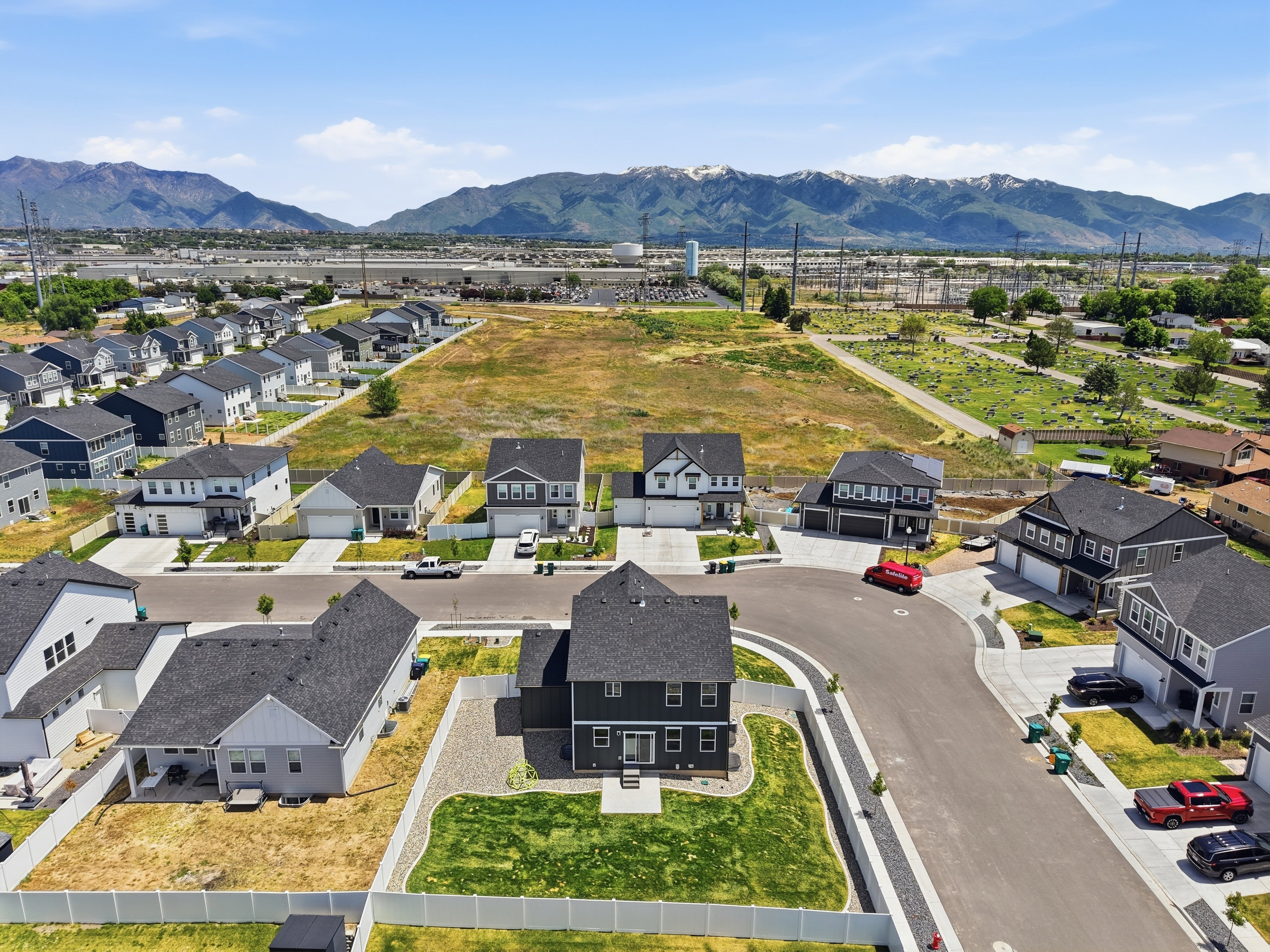 Contemporary residential development featuring a cul-de-sac design, uniform architectural styles, and mountain range scenery