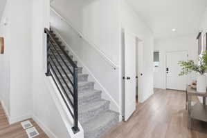 Modern staircase featuring black metal railings and grey carpeted treads