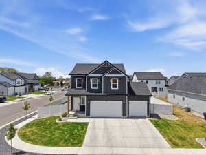 Contemporary two-story residence featuring dark siding with white trim accents and a contrasting dark roof