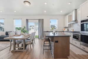 Open-concept living space featuring wood-finish flooring, recessed lighting, and a sliding glass door