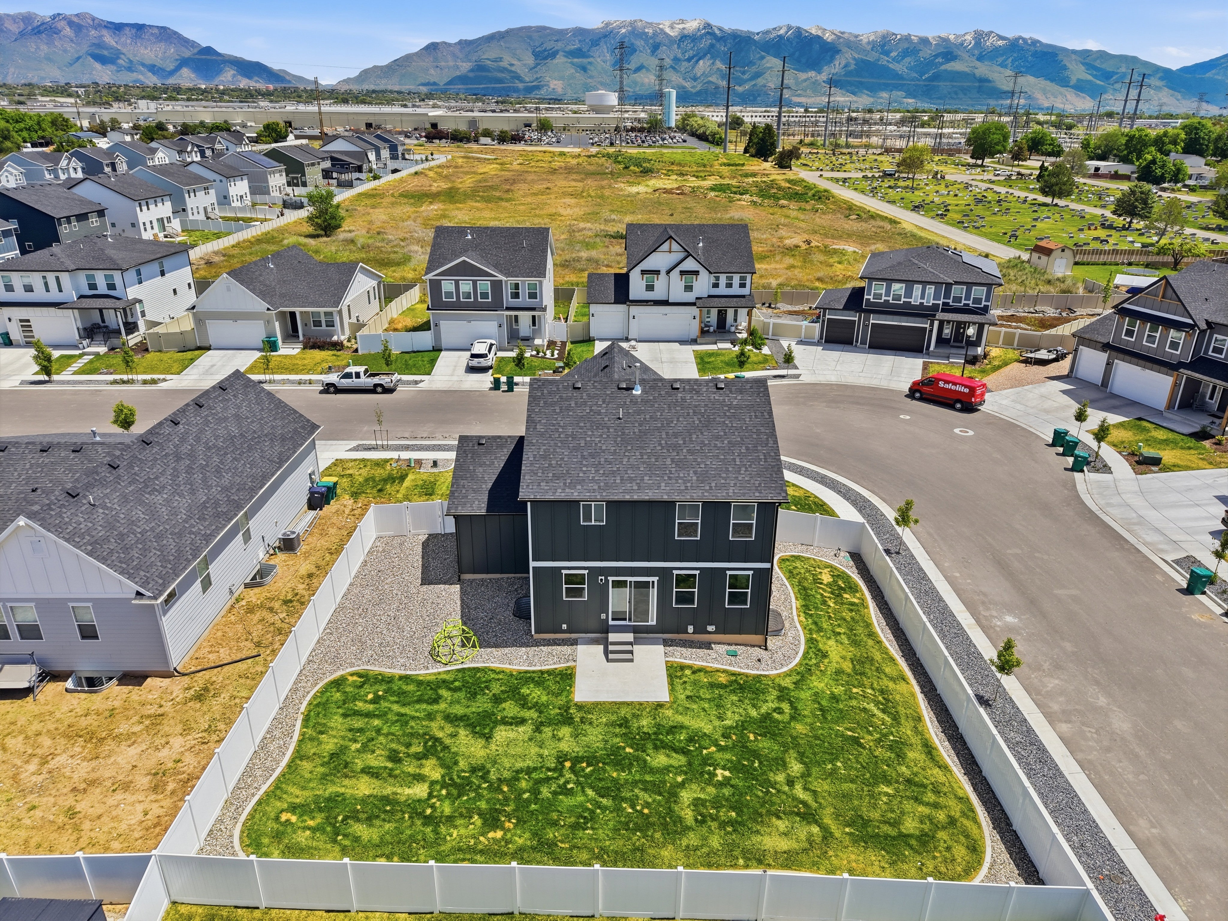 New construction residence featuring a dark gray exterior with white trim accents and a fenced backyard