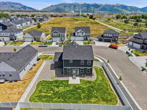 New construction residence featuring a dark gray exterior with white trim accents and a fenced backyard